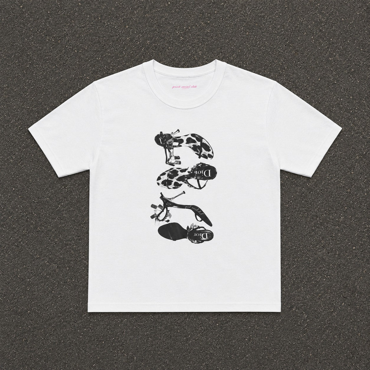 Heels Baby Tee in white, flat lay with a black and white stack of heels print