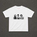 Iconic 3 Baby Tee in white, flat lay with a black and white three portraits print