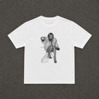 Moss Baby Tee in white, flat lay with a black and white fur coat portrait print